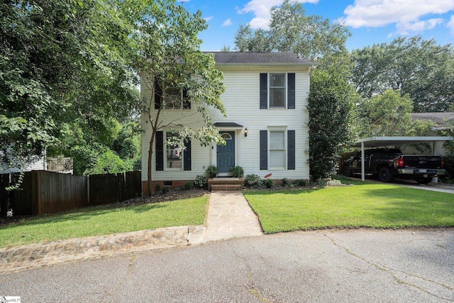 colonial house with a front yard and a carport