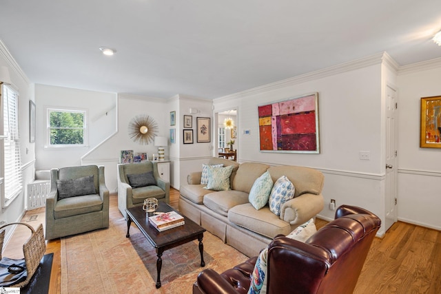 living room with crown molding and light hardwood / wood-style flooring