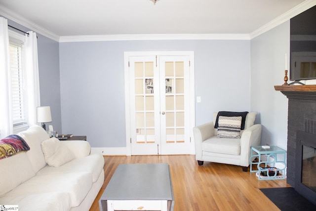 living room featuring light hardwood / wood-style floors, crown molding, and a brick fireplace