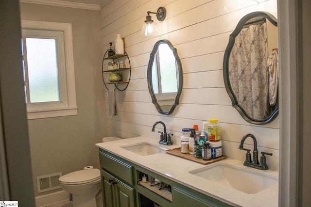 bathroom featuring vanity, toilet, and crown molding