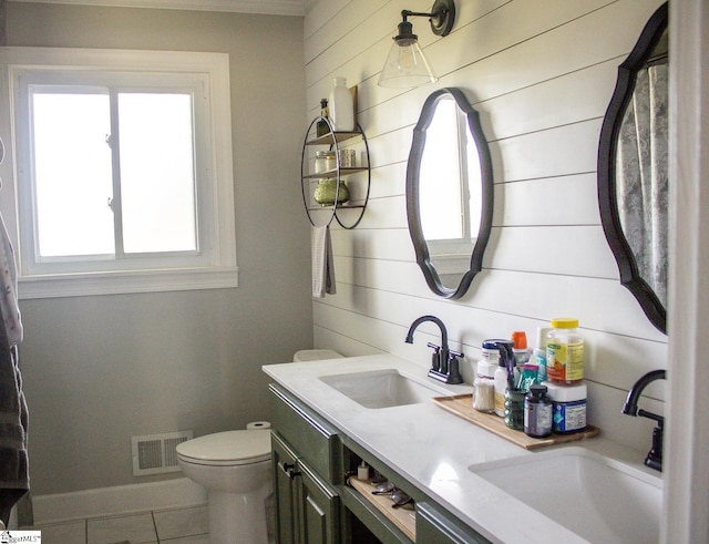 bathroom featuring wooden walls, tile patterned flooring, vanity, and toilet