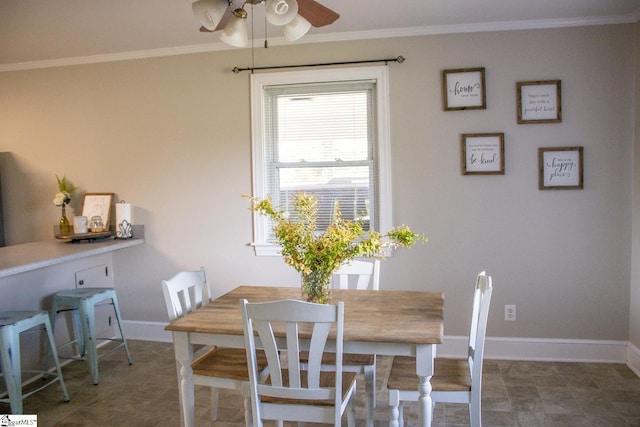 dining space with ceiling fan and crown molding