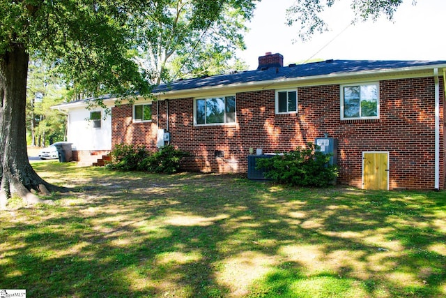 back of house with a lawn and central air condition unit