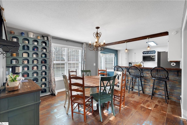 dining room featuring beamed ceiling, a textured ceiling, and a notable chandelier