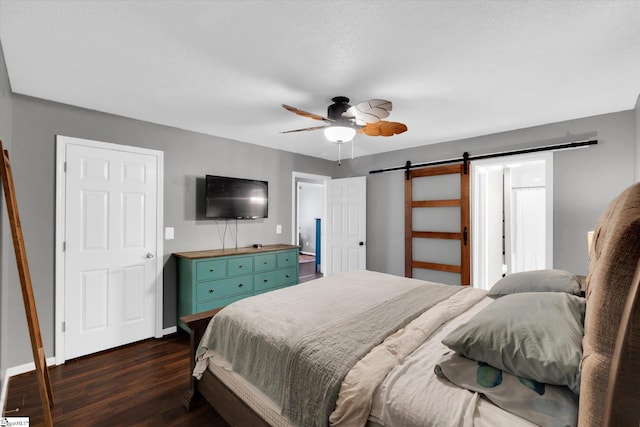 bedroom featuring ceiling fan, a barn door, and dark hardwood / wood-style floors