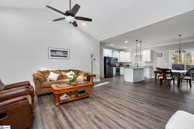 living room with dark hardwood / wood-style flooring, ornamental molding, ceiling fan with notable chandelier, and sink