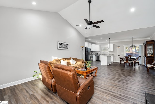 living room with dark wood-type flooring, high vaulted ceiling, ceiling fan with notable chandelier, crown molding, and sink