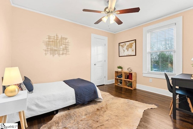 bedroom with ceiling fan, ornamental molding, and dark wood-type flooring