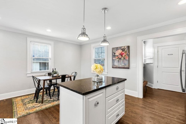 kitchen featuring pendant lighting, white cabinetry, and ornamental molding