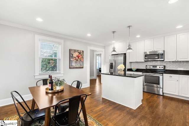 kitchen featuring dark hardwood / wood-style flooring, stainless steel appliances, a kitchen island, decorative light fixtures, and white cabinetry