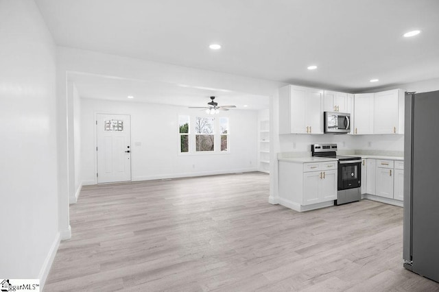 kitchen featuring white cabinets, stainless steel appliances, ceiling fan, and light hardwood / wood-style floors