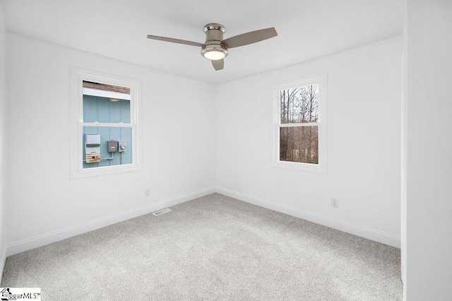 empty room featuring ceiling fan and carpet