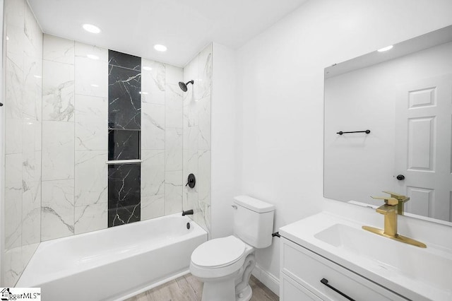 full bathroom with vanity, hardwood / wood-style floors, tiled shower / bath combo, and toilet