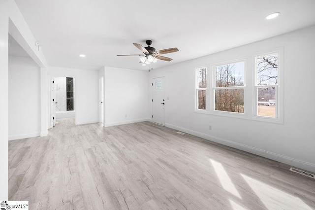 spare room with light wood-type flooring and ceiling fan