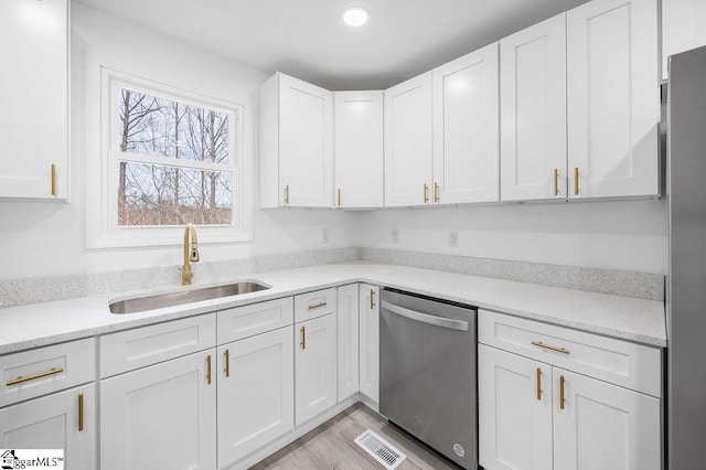 kitchen with light hardwood / wood-style flooring, stainless steel appliances, white cabinetry, and sink