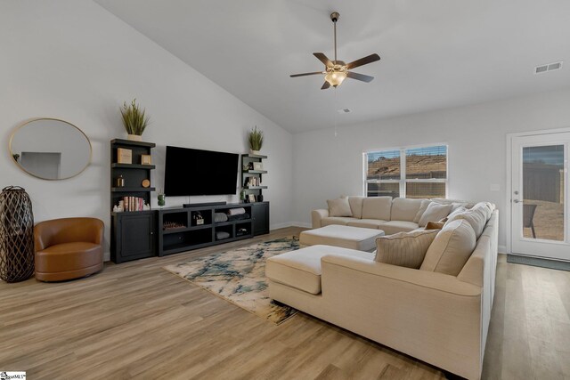 living room with ceiling fan, light hardwood / wood-style flooring, and high vaulted ceiling