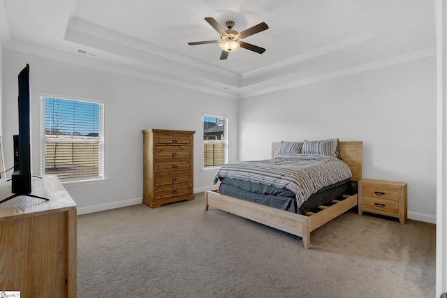 carpeted bedroom featuring a raised ceiling, ceiling fan, and ornamental molding