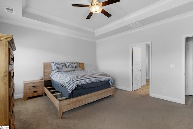 bedroom with light colored carpet, a raised ceiling, ceiling fan, and crown molding