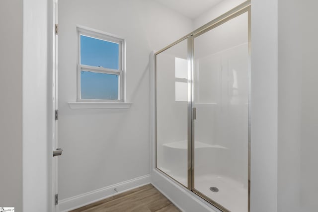 bathroom featuring hardwood / wood-style flooring and a shower with shower door