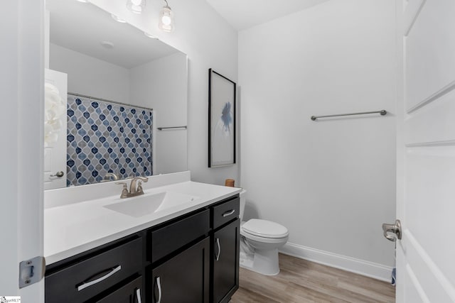 bathroom featuring vanity, hardwood / wood-style flooring, and toilet