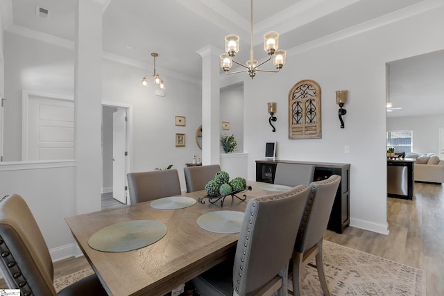 dining room with light hardwood / wood-style floors, crown molding, and a chandelier