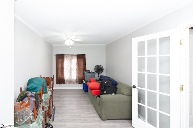 living room featuring ceiling fan, crown molding, and light wood-type flooring