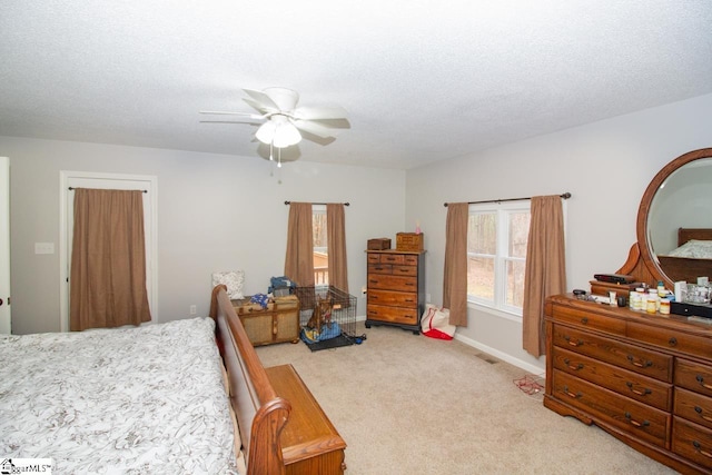 bedroom with a textured ceiling, ceiling fan, and light carpet