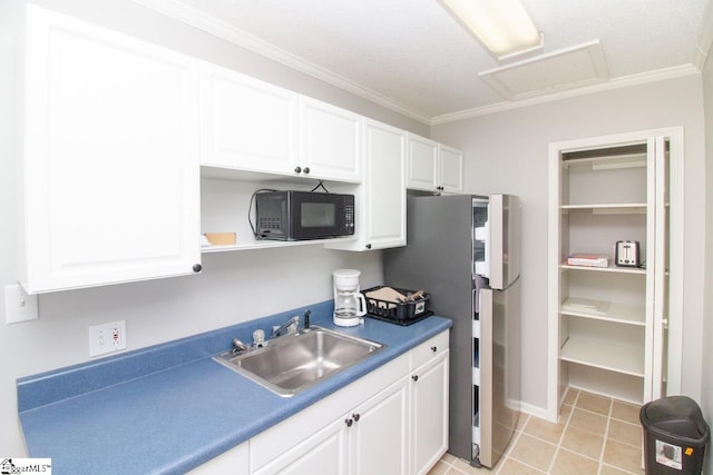 kitchen with stainless steel refrigerator, white cabinetry, sink, light tile patterned flooring, and ornamental molding