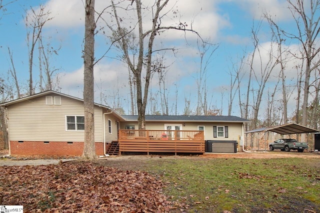 back of property with a wooden deck, a yard, a hot tub, and a carport