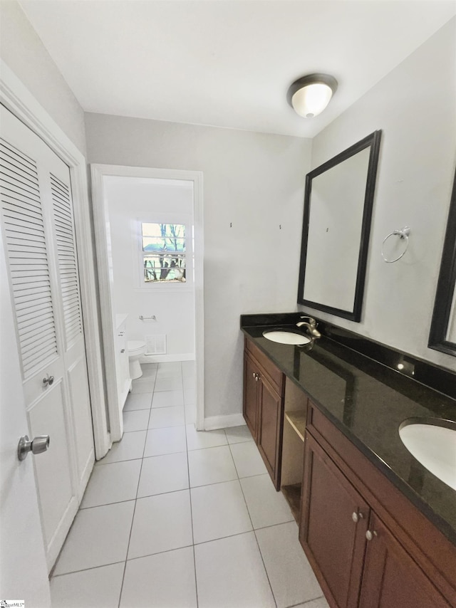 bathroom featuring tile patterned flooring, vanity, and toilet