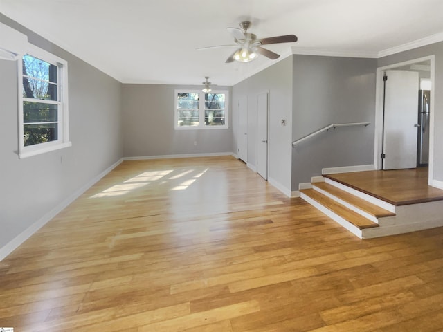 spare room featuring ceiling fan, light wood-type flooring, and ornamental molding