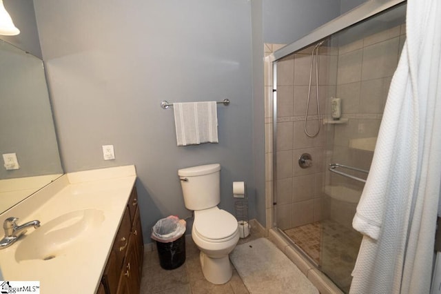 bathroom with tile patterned flooring, toilet, vanity, and walk in shower