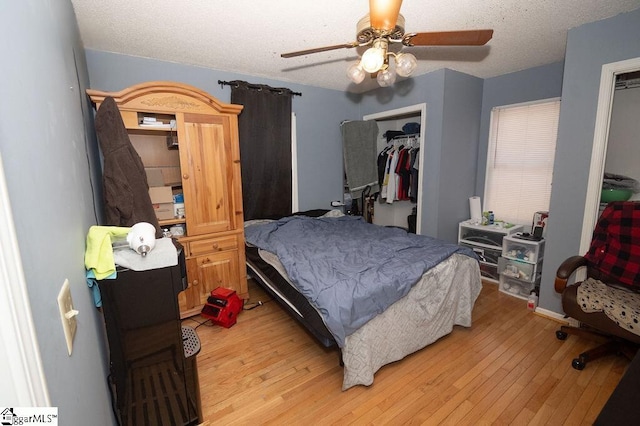 bedroom with a textured ceiling, light wood-type flooring, a closet, and ceiling fan