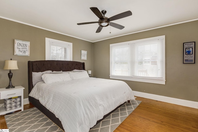 bedroom with ceiling fan, crown molding, and wood-type flooring