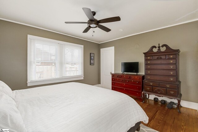 bedroom with dark hardwood / wood-style flooring, ceiling fan, and ornamental molding