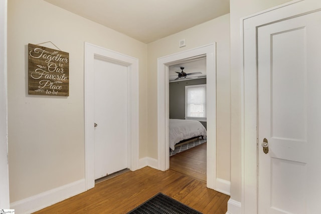 corridor with hardwood / wood-style flooring