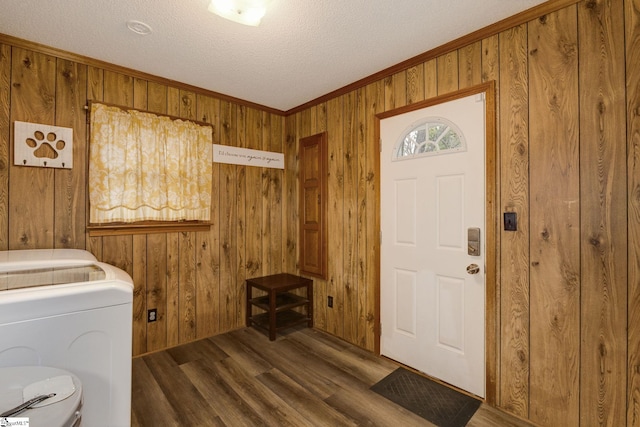 laundry area featuring ornamental molding, a textured ceiling, dark wood-type flooring, wooden walls, and washer / dryer