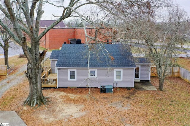 rear view of property featuring a wooden deck and central AC