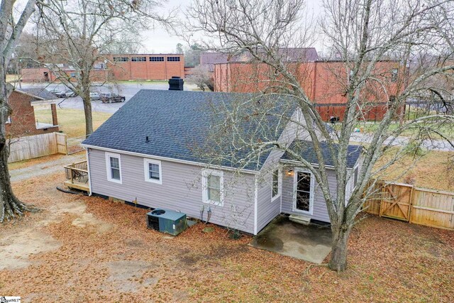 rear view of property with central AC