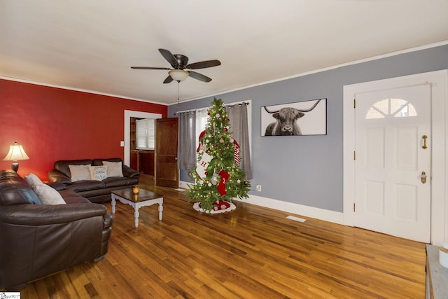 living room with hardwood / wood-style flooring, ceiling fan, and crown molding