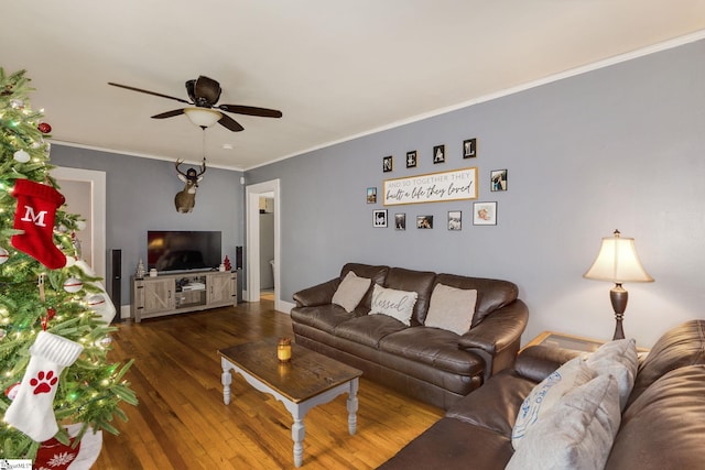 living room with ceiling fan, crown molding, and dark wood-type flooring