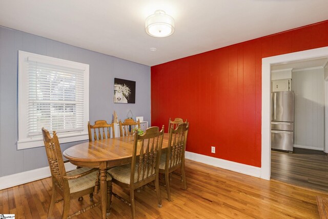 dining space with hardwood / wood-style floors