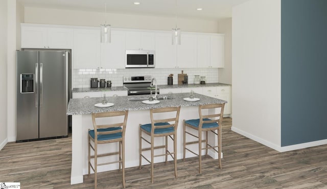 kitchen featuring white cabinets, sink, stainless steel appliances, and an island with sink