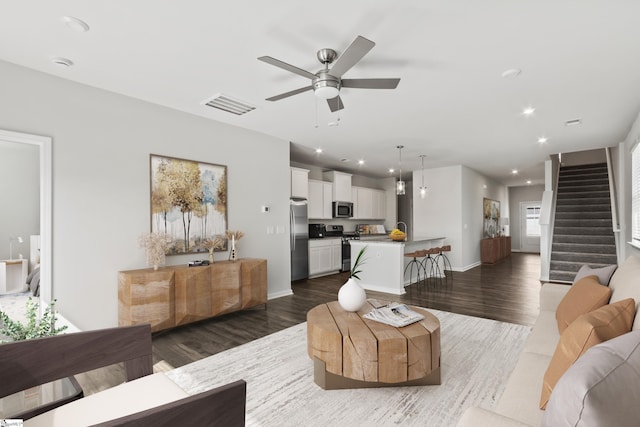 living room featuring dark hardwood / wood-style flooring and ceiling fan