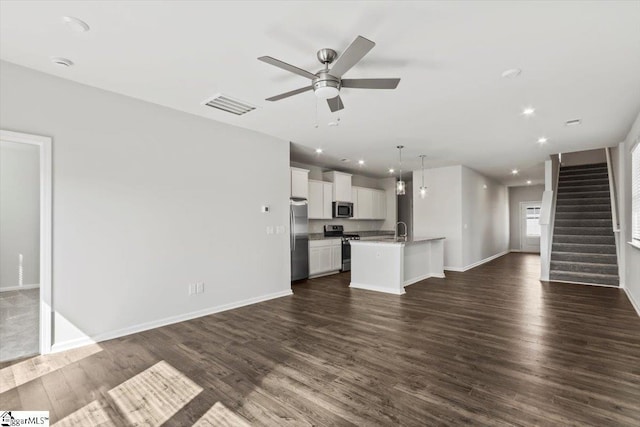 unfurnished living room featuring dark hardwood / wood-style floors, ceiling fan, and sink