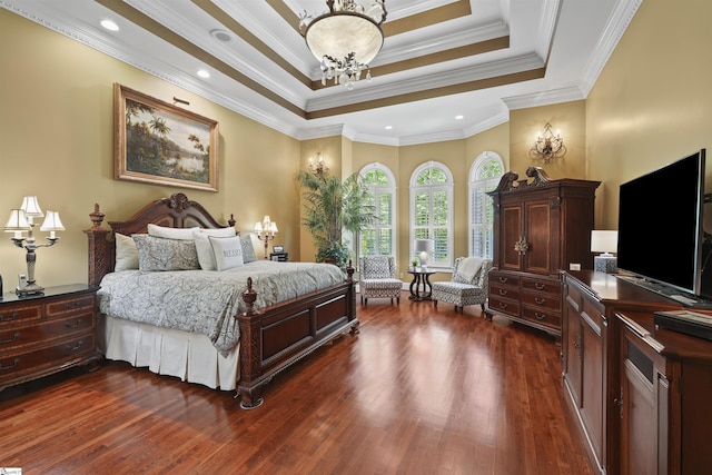 bedroom with a tray ceiling, a chandelier, dark hardwood / wood-style floors, and ornamental molding