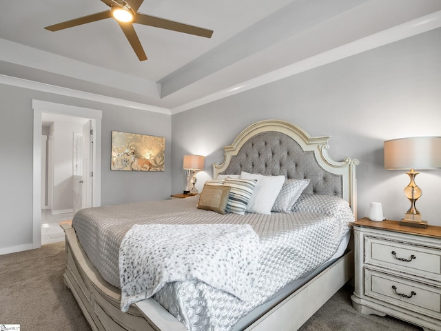 bedroom with carpet floors, ensuite bathroom, a raised ceiling, and ceiling fan