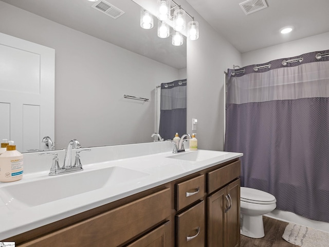 full bathroom featuring hardwood / wood-style floors, vanity, shower / bath combo, and toilet