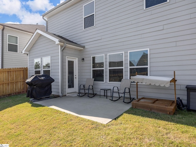 rear view of house with a lawn and a patio area