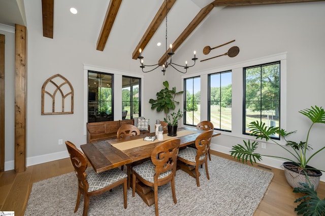 dining area with beam ceiling, light hardwood / wood-style flooring, high vaulted ceiling, and a chandelier